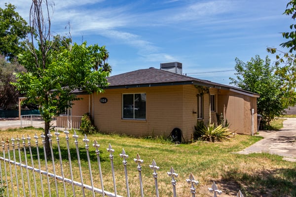 This angle emphasizes the expansive front yard, mature shade trees, long driveway, and ample outdoor space. The property offers outstanding versatility with no HOA and room for future improvements.