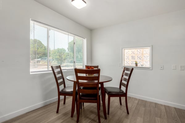 The dining area offers oversized windows, updated flooring, and an inviting setting for casual meals or formal gatherings. Bright natural light enhances the clean, modern feel of this remodeled Mesa home.