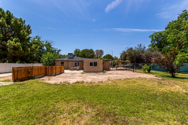 Spacious backyard showcasing patio access, mature trees, and extensive open space ready for entertaining, play, gardening, or future customization. An exceptional outdoor feature in Mesa.