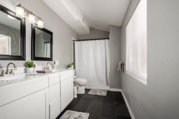 Bright ensuite bathroom showcasing a double-sink vanity, updated fixtures, modern cabinetry, and generous natural light. Designed for comfort and everyday convenience in this Mesa property.