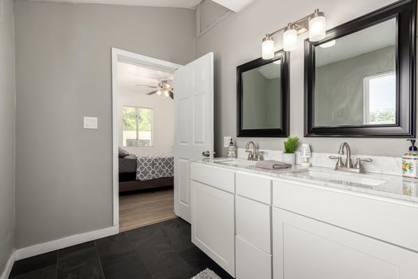 Stylish primary bathroom featuring dual sinks, updated cabinetry, modern mirrors, and ample storage. A thoughtfully updated space that enhances this move-in-ready Mesa home.