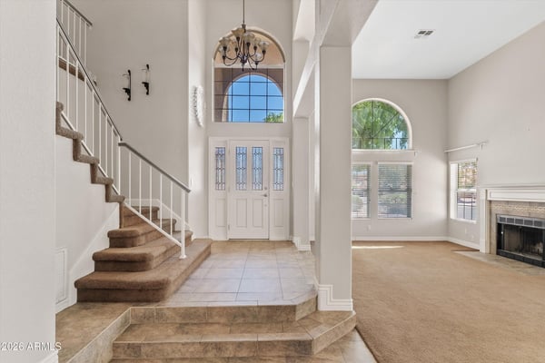 From the grand front entrance, enjoy views into the expansive living space featuring soaring ceilings, oversized windows, and abundant natural light. The open design enhances both comfort and entertaining.
