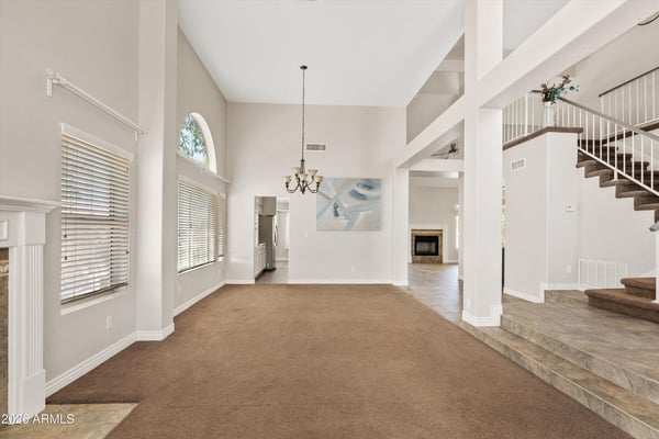 This generous living room offers soaring ceilings, oversized windows, and an open design that creates a bright, welcoming atmosphere. Perfect for everyday comfort or hosting family gatherings.