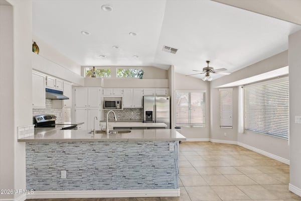 This bright kitchen offers updated cabinetry, newer countertops, stainless steel appliances, a large center island, and a sunny breakfast area. The open design provides an ideal setting for cooking, casual dining, and entertaining while enjoying seamless flow to the surrounding living spaces.