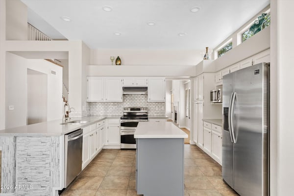 This updated kitchen showcases newer cabinetry, modern countertops, stainless steel appliances, recessed lighting, and a spacious center island. The open layout makes meal preparation and entertaining effortless in this Chandler home.