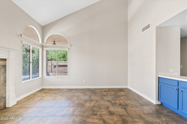 Vaulted ceilings and oversized windows create a bright, open family room with plenty of space for relaxing or entertaining. Its seamless connection to the kitchen enhances the home's functional floor plan.
