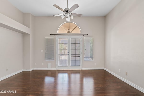 Relax in the generous main-floor primary suite featuring wood flooring, vaulted ceilings, and French doors opening to the backyard. This peaceful retreat combines comfort, privacy, and direct outdoor access.