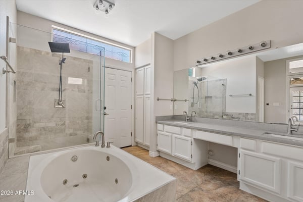 The primary bathroom offers an oversized vanity, glass walk-in shower, jetted soaking tub, and plentiful storage. Modern finishes and spacious design create a true spa-inspired retreat.