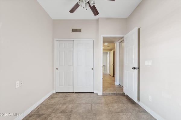 Featuring tile flooring, ceiling fan, and generous closet storage, this flexible bedroom easily accommodates guests, family, or a productive home office.