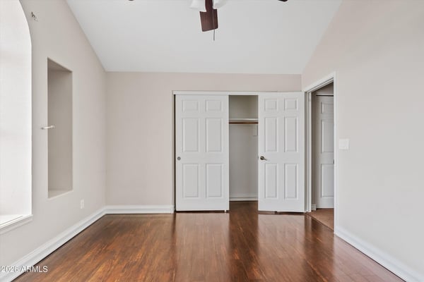 Wood flooring, ceiling fan, and a generously sized closet enhance this comfortable bedroom. The flexible layout works equally well for guests, family members, or a home office.