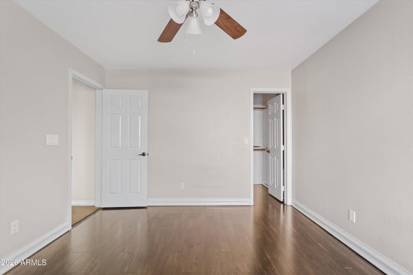 This spacious bedroom offers attractive wood flooring, neutral finishes, ceiling fan, and convenient access to nearby storage. A flexible room that adapts to your needs.