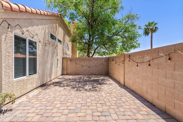 The spacious paver patio offers additional outdoor living space ideal for grilling, outdoor dining, or creating a peaceful sitting area. Mature landscaping adds shade and privacy to this Chandler backyard.