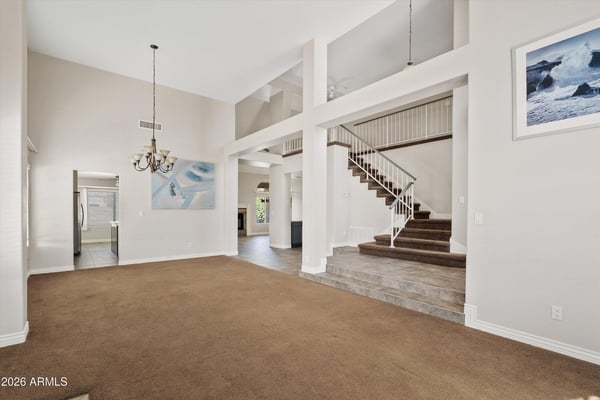 Enjoy an expansive open living space featuring soaring ceilings, a dramatic staircase, and abundant natural light. The thoughtful layout creates an inviting atmosphere that flows effortlessly into the adjoining living areas, making it ideal for entertaining or relaxing.