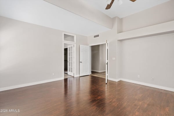 The spacious primary bedroom offers elegant wood flooring, vaulted ceilings, and excellent natural light. Its thoughtful layout provides plenty of room for additional seating and direct access to the ensuite bathroom.
