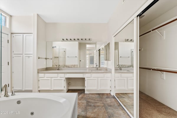 The primary ensuite features a dual-sink vanity, jetted soaking tub, spacious walk-in closet, and abundant cabinetry. Designed for comfort and convenience, it creates a relaxing owner's retreat.