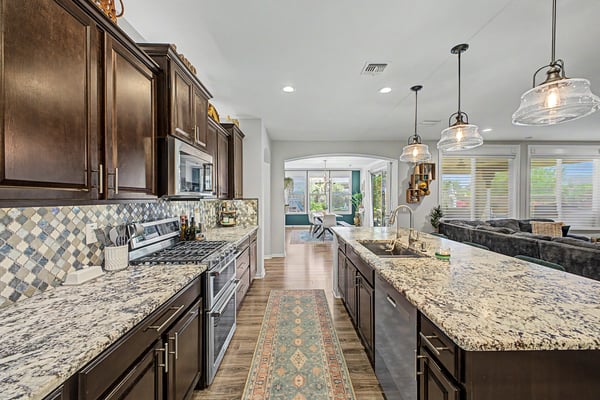 Enjoy preparing meals in this beautifully appointed kitchen with granite counters, stainless steel appliances, custom cabinetry, decorative backsplash, and an expansive center island.