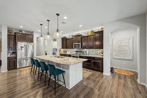 Open-concept kitchen with granite countertops, oversized island, abundant cabinetry, recessed lighting, and seamless flow into the main living spaces, creating an inviting gathering place.
