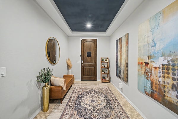 Bright front entry with upgraded flooring, architectural details, custom wood door, and designer touches that offer a warm and inviting introduction to the home's spacious interior.