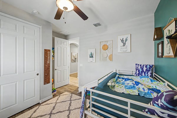 Alternate angle of the secondary bedroom highlights upgraded flooring, stylish d cor, natural light, and a functional layout that complements the home's thoughtful design.