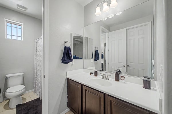 Ensuite bathroom offers a large vanity, modern cabinetry, quality fixtures, and convenient access, complementing the home's spacious bedroom layout.