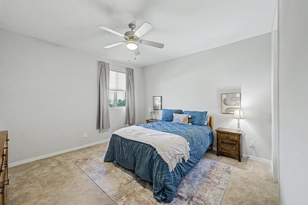 Spacious guest bedroom offers neutral d cor, plush carpeting, ceiling fan, and excellent natural light, creating an inviting retreat for visitors or everyday living.