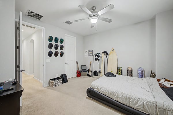 Oversized bedroom provides exceptional flexibility with generous square footage, plush carpeting, ceiling fan, and room for multiple furniture arrangements.