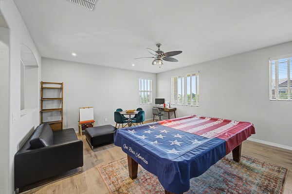 Expansive bonus room features upgraded flooring, recessed lighting, ceiling fan, and multiple windows, making it ideal as a game room, media room, home office, or additional family living space.