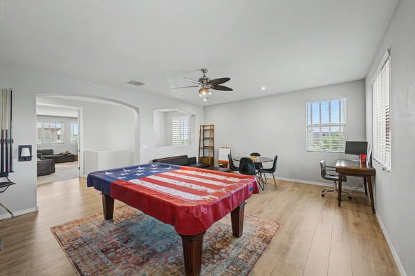 Open recreation room features upgraded flooring, ceiling fan, recessed lighting, and flexible space for games, entertaining, or creating a personalized lifestyle area.