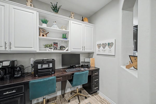 Built-in office area offers custom cabinetry, dual desks, ample storage, and a practical workspace perfect for remote work, homework, or household organization.