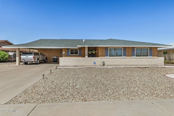 Attractive Sun City home with fresh exterior appeal, a new roof, covered golf cart parking, spacious driveway, and easy-care desert landscaping designed for low-maintenance living.
