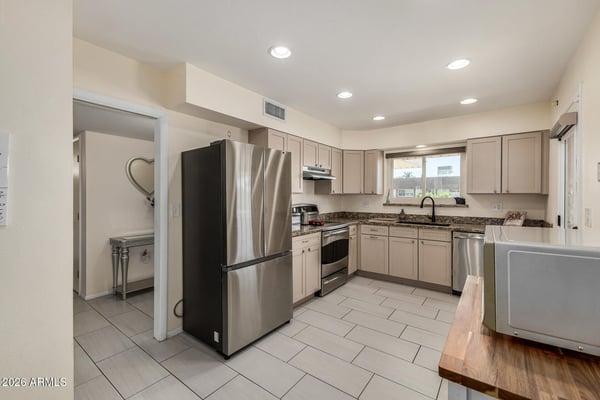 Well-appointed kitchen with granite counters, stainless steel appliances, recessed lighting, abundant cabinet storage, and a bright workspace designed for daily functionality.