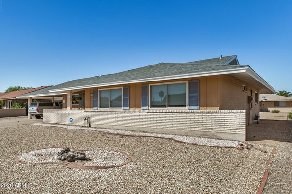 Beautiful exterior angle showcasing the home's updated roof, attractive architectural details, low-maintenance desert landscaping, and welcoming curb appeal.