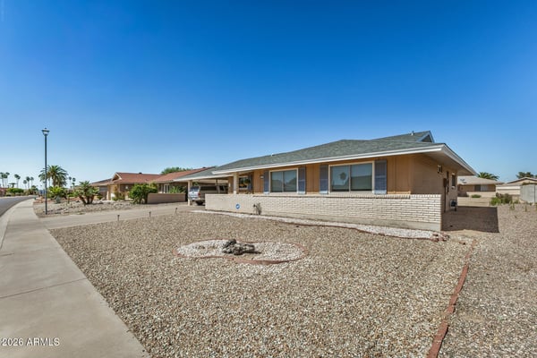 Attractive front fa ade features a broad driveway, covered parking, and professionally maintained desert landscaping. This Sun City property welcomes guests with timeless curb appeal.