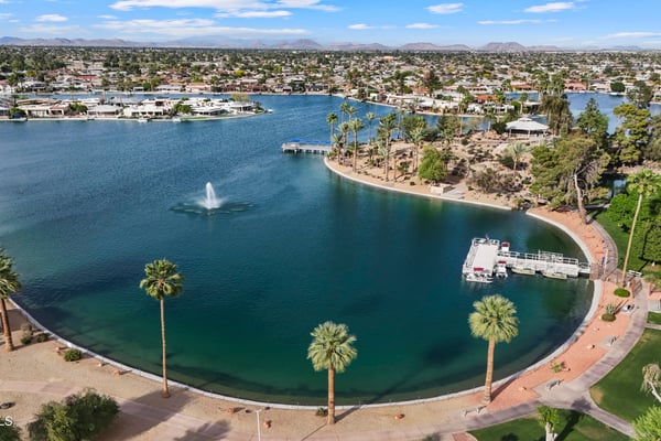 Scenic aerial captures the nearby lake, walking trails, landscaped shoreline, and relaxing outdoor spaces that make Sun City an enjoyable place to call home.