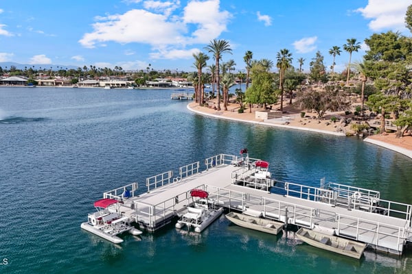 Beautiful aerial captures the nearby marina with boat docks, tranquil lake views, and landscaped shoreline. Enjoy convenient waterfront recreation in desirable Sun City.