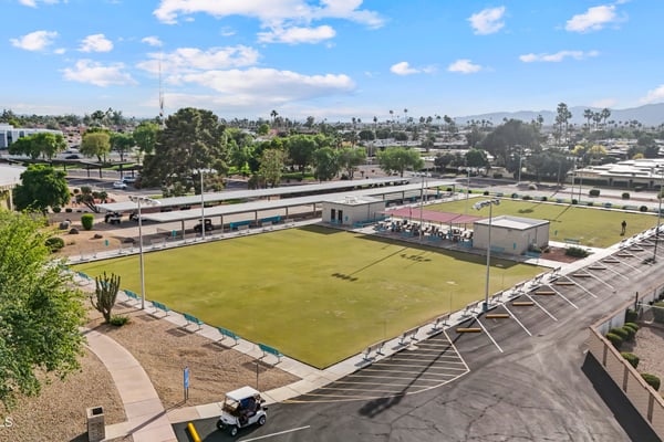 Aerial image features nearby lawn bowling greens, gathering areas, and landscaped recreation spaces. Sun City provides a variety of outdoor amenities for recreation and leisure.