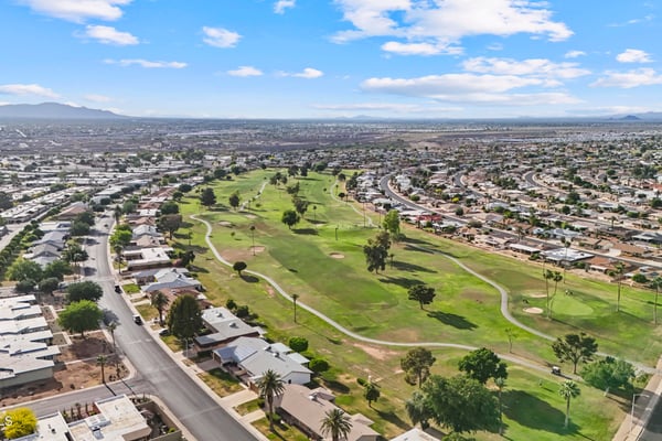 Elevated aerial showcases lush fairways, winding golf cart paths, mature trees, and beautifully maintained open spaces. Sun City offers a picturesque golf-oriented setting with abundant recreation.