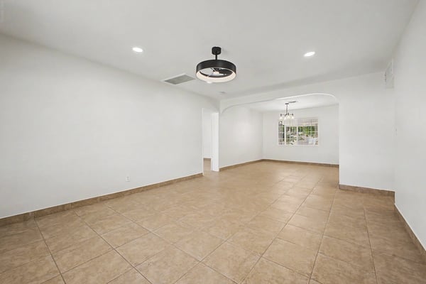 Spacious great room with an open layout, neutral finishes, tile flooring, recessed lighting, and seamless flow into the dining area, offering flexible living space for a variety of lifestyles.