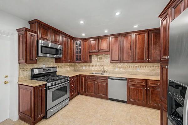 Well-designed kitchen featuring granite countertops, abundant cabinet storage, stainless steel appliances, recessed lighting, and decorative backsplash, offering style and functionality for everyday living in Phoenix.