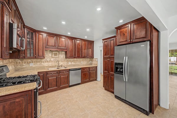 Bright kitchen with expansive countertops, extensive cabinetry, stainless steel refrigerator, recessed lighting, and an open layout that flows effortlessly into the home's living spaces in Phoenix.