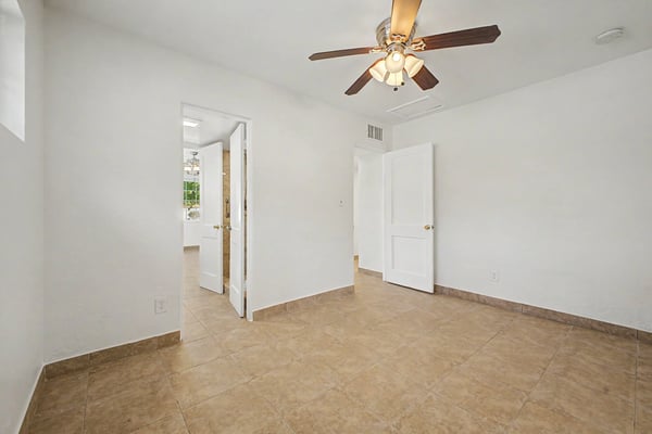 Bright flex room with tile flooring, ceiling fan, neutral color palette, and generous living space. Perfect for a home office, guest suite, hobby room, or additional family room in this Phoenix home.