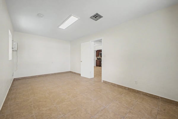 Expansive bonus living area with tile flooring, overhead lighting, and convenient connection to the kitchen. Ideal for entertaining, relaxing, exercising, or creating a customized living environment in this Phoenix property.