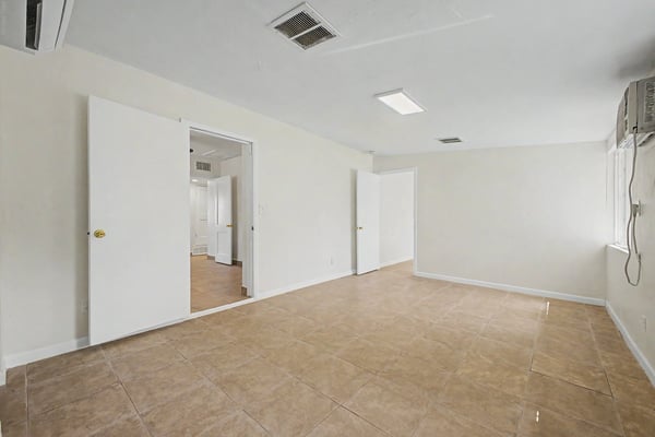 Oversized family room featuring durable tile flooring, bright windows, and an open layout ready for entertaining, recreation, or additional living space. A flexible room that adapts to a variety of needs.