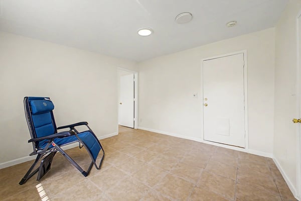 Spacious bonus room with neutral finishes, tile flooring, recessed lighting, and private entrance. Perfect for a home office, guest quarters, recreation room, or additional family living space in this Phoenix property.