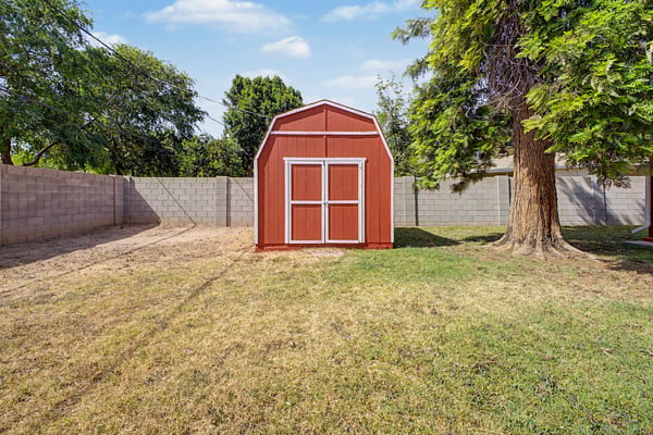 Detached storage building provides convenient space for lawn equipment, gardening tools, seasonal items, or workshop needs. Located within the expansive backyard, this practical feature adds lasting value to this Phoenix property.