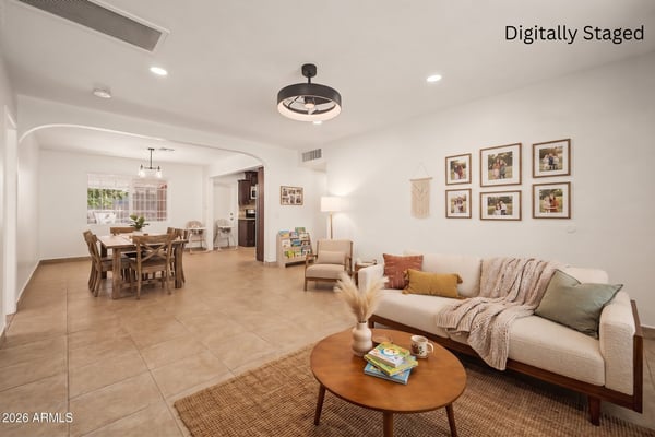 Digitally staged open-concept great room featuring comfortable seating, dining space, and a welcoming layout that helps buyers visualize the home's entertaining potential in Phoenix.