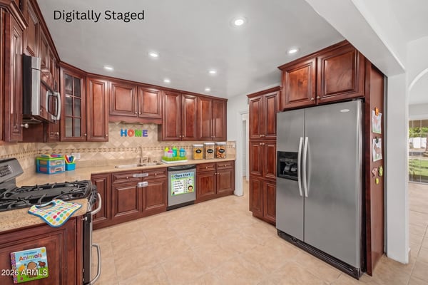 Digitally staged kitchen highlighting generous cabinet storage, granite countertops, stainless steel appliances, decorative backsplash, and a functional layout that showcases the heart of this Phoenix home.