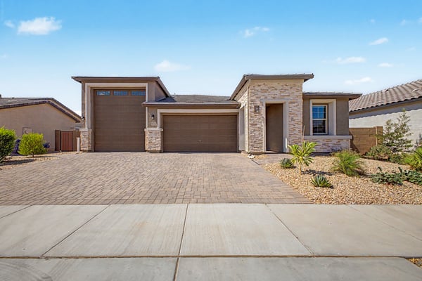 Beautifully designed single-level home featuring striking stone accents, a spacious paver driveway, oversized RV garage, and attractive desert landscaping. A premium home offering style, functionality, and outstanding curb appeal in Wittman.