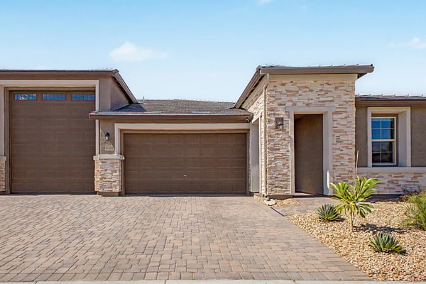 Clean architectural lines, stone veneer, covered entry, and oversized garage spaces create an impressive front elevation. Low-maintenance landscaping enhances the home's modern design and easy-care lifestyle.