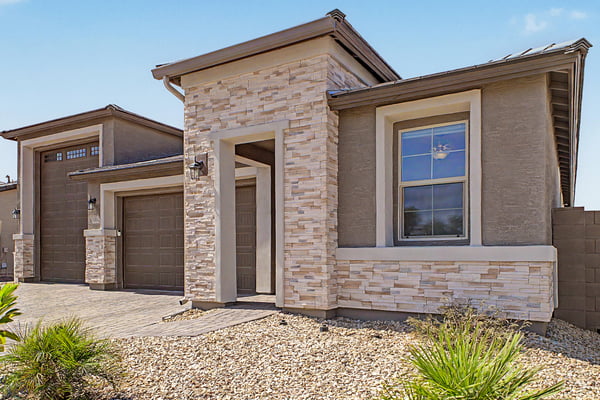 Professionally landscaped front yard, modern architecture, and premium stone accents combine to create an attractive exterior designed for low-maintenance living in Wittman.